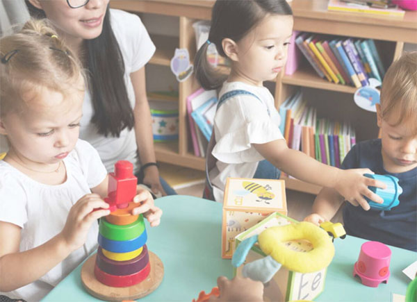 Kids playing with colorful toys on a table in a daycare.